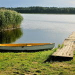 Kleines Holzboot am Steg eines Sees in den Masuren